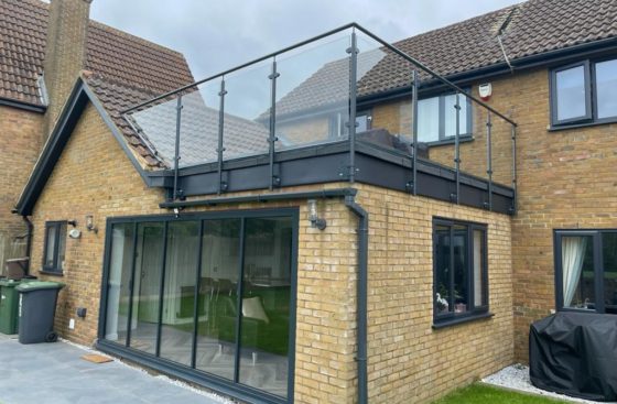 Side-mounted post & rail system around a flat roof.