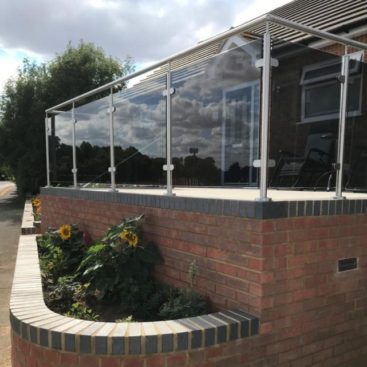 Post & Rail system with grey tinted glass around a patio area